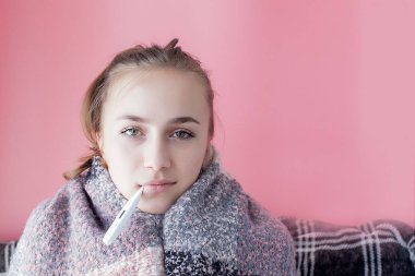 Grip soğuk kavradı. Yüksek ateşi olan bir kadın. Pembe arka planda cıva termometre kontrol ateş ile hasta kız.