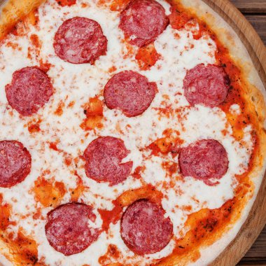 Salam koyu ahşap arka plan üstten görünüm üzerinde İtalyan biberli pizza. Geleneksel İtalyan yemekleri. Seçme sokak gıda