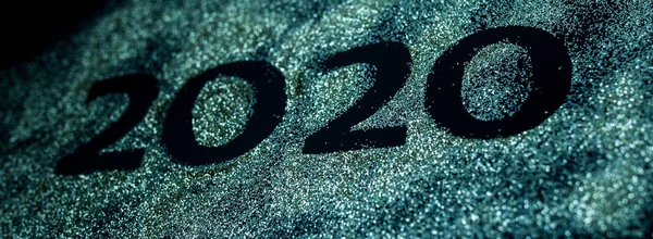 Happy New Year 2020. Creative Collage of numbers two and zero made up the year 2020. Beautiful sparkling Golden number 2020 on black background for design.