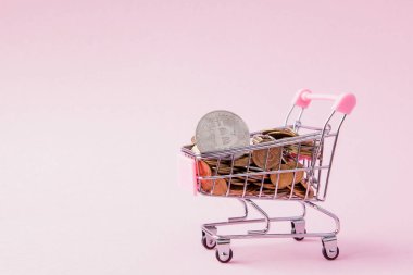 Bitcoin ve sikkeler üzerinde alışveriş sepeti içinde arka plan pembe