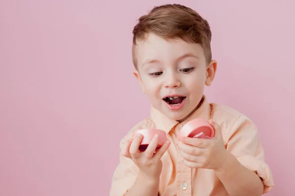 Um rapazinho feliz com um dom. Foto isolada em fundo rosa — Fotografia de Stock