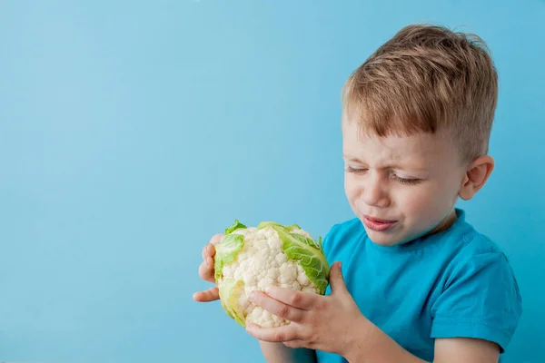 Little Boy Holding Broccoli in his hands on blue background, die — Stock Photo, Image