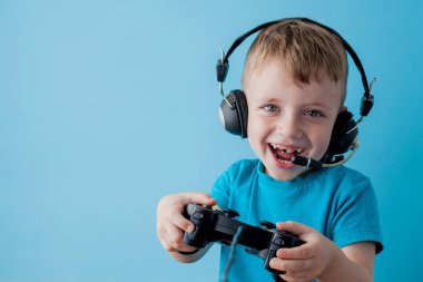 Küçük çocuk çocuk 2-3 yaşında mavi giysiler giyen gameson mavi arka plan çocuk stüdyo portre için el joystick tutun. İnsanlar çocukluk yaşam tarzı kavramı. Kopya alanı yla alay edin