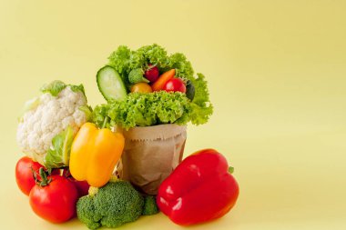 Organik sebze brokoli salatalık biber kahverengi kağıt Kraft bakkal çanta sarı arka plan elma. Sağlıklı diyet diyet lif vegan plastik ücretsiz kavram. Afiş afişi