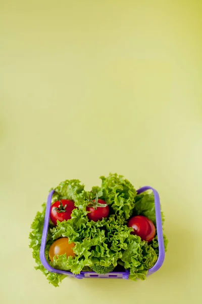 Kleine verse groenten in mand op gele achtergrond. Voedsel achtergrond concept met copyspace — Stockfoto