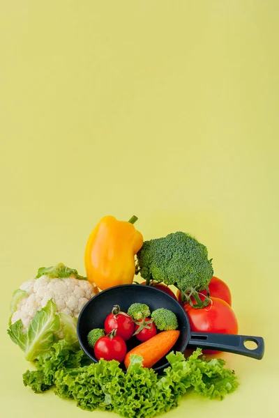 Органічні продукти харчування. Здорові овочі з брокколі, салат, червоний і жовтий солодкий перець, огірок на чорній сковороді. Вид зверху. Вегетаріанець і здорова концепція. — стокове фото
