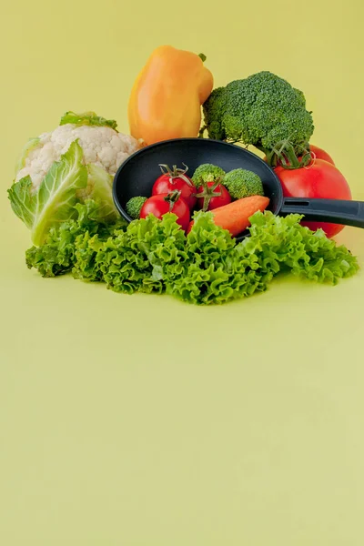 Свіжі овочі на сковороді на жовтому фоні. Веган і зцілення — стокове фото