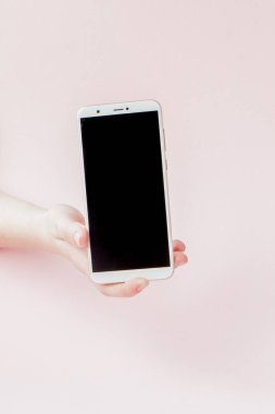Pembe arka planda bir kadının elinde modern cep telefonu