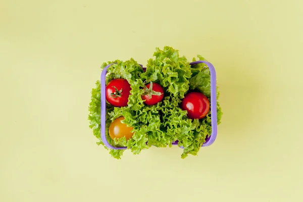 Pequenas verduras frescas na cesta no fundo amarelo. Comida de volta — Fotografia de Stock