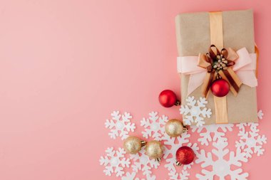 Pembe arka planda kurdeleyle sarılı küçük hediyelerin yakın çekimi. Noel arkaplanı. Minimum konsept. Düz yatıyordu. Üst görünüm