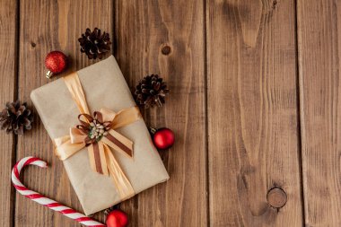 Noel konileri ve oyuncakları, köknar dalları, hediye kutuları ve ahşap bir masa arkasındaki süslemelerle Noel arkaplanı