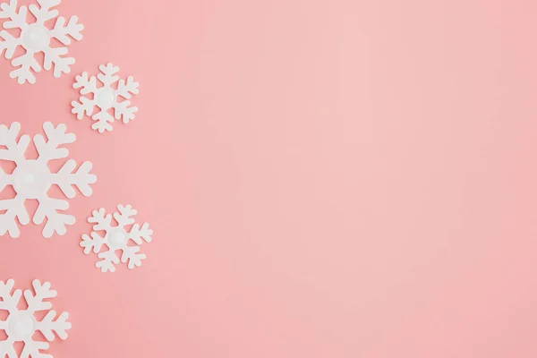 Téli mintázat hópelyhek és rózsaszín háttér. Karácsonyi koncepció. Lapos feküdt. Hely másolása a szövegbe — Stock Fotó
