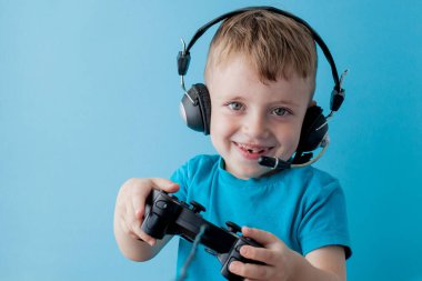 Küçük çocuk çocuk 2-3 yaşında mavi giysiler giyen gameson mavi arka plan çocuk stüdyo portre için el joystick tutun. İnsanlar çocukluk yaşam tarzı kavramı. Kopya alanı yla alay edin