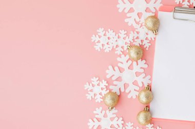 Kadınların elinde Noel hediyesi ve pembe bir popo grubunda defter.