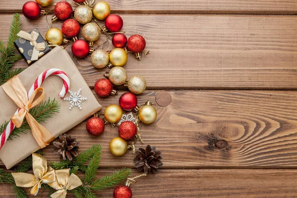 Vánoční dárková krabička, potravin výzdobou a jedlové větve stromu dřevěné kartě — Stock fotografie