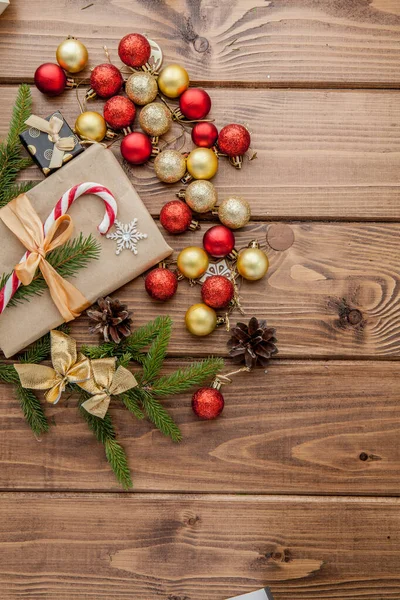 Kerstgeschenkdoos, eetdecor en dennenboom tak op houten tafel. Bovenaanzicht met kopieerruimte — Stockfoto