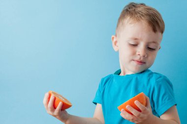 Little Boy mavi arka plan, di elinde bir Portakal Holding