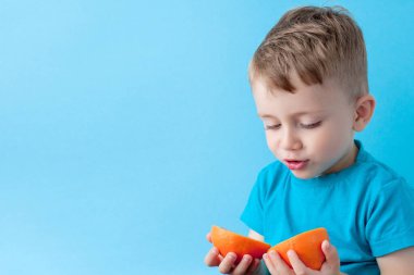 Little Boy mavi arka plan, di elinde bir Portakal Holding