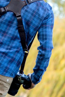 Profesyonel fotoğrafçı omuz bandında iki kamerayla iş başında.