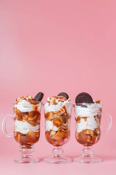 Dolce dessert in vetro con biscotto e panna montata su bs rosa — Foto Stock