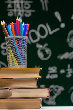 Okul kitapları ve karatahtaya karşı arkaplanda 