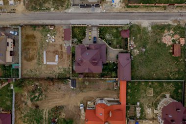 Asfaltlı, yeşil çimenli çimenli, beton zeminli bir evin havadan görünüşü.