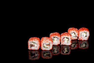 Philadelphia rulosu somon, peynir ve salatalık ile siyah arka planda yansımalı. Suşi Philadelphia