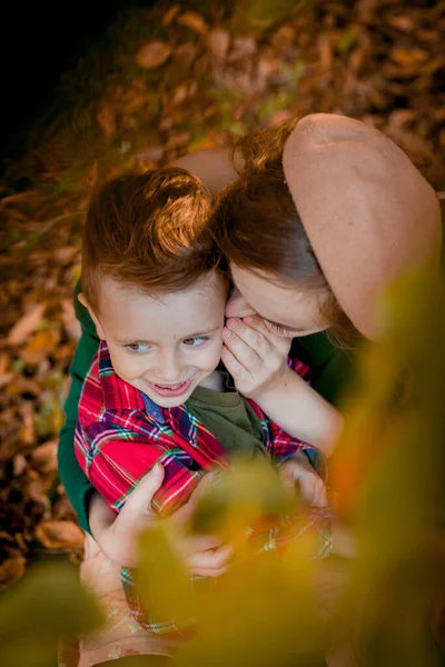 Šťastná mladá matka hrát a bavit se se svým malým synem na slunci teplý podzimní den v parku. Šťastný rodinný koncept — Stock fotografie