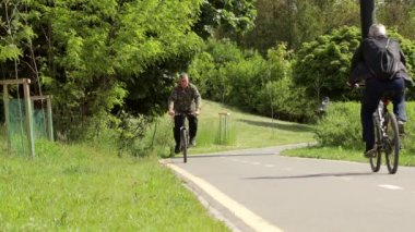 İvano-Frankivsk, 29 Mayıs 2020: Şehir yolunda bisiklet sürmek, yol işaretinin yanında bisiklet süren tanınmamış bir bisikletçinin gölgesi. Sağlıklı bisiklet yaşam tarzı