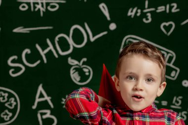 Ev ya da okul eğitimi. Kağıttan uçağı olan bir öğrenci. İlkokuldan portre çocuğu