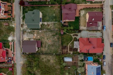 Asfaltlı, yeşil çimenli çimenli, beton zeminli bir evin havadan görünüşü.