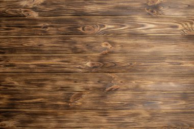 Arkaplanda çizikler olan koyu kahverengi ahşap doku.