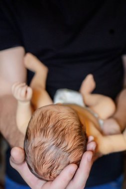 Babası 15 günlük oğlunu siyah arka planda tutuyordu..