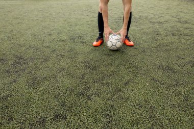 Futbol sahasında ayakları olan bir futbol topu.