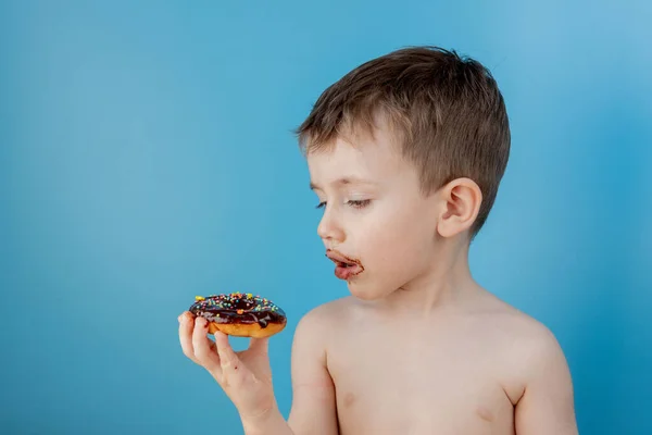 Маленький Мальчик Ест Шоколадный Пончик Синем Фоне Милый Счастливый Мальчик — стоковое фото
