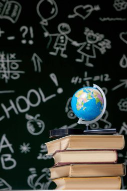 Yeşil karatahta arkaplan üzerine kitap yığını, okul konseptine geri dönüş.