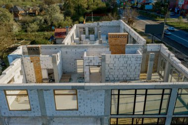 Beyaz köpük beton bloklardan yapılmış inşaat halindeki bir evin inşaatı. Yeni ev çerçevesi oluşturuluyor.