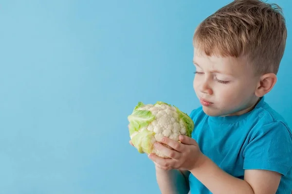 Little Boy Segurando Brócolis Suas Mãos Sobre Fundo Azul Dieta — Fotografia de Stock