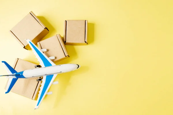 Airplane and stack of cardboard boxes. concept of air cargo and parcels, airmail. Fast delivery of goods and products. Cargo aircraft. Logistics, connection to hard-to-reach places. Banner, copy space.