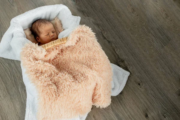 Un neonato di due settimane che dorme in una scatola di legno vintage. Girato in studio su uno sfondo di legno. — Foto Stock