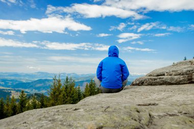 Harika bir dağ yerinde yoga yapan genç adam, yeni bir çağ, enerji, meditasyon ve sağlık, lotus pozisyonunda gülümseyen genç adam.
