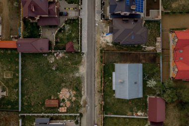 Beton zeminli yeşil çimenli asfalt bahçeli özel bir evin havadan görünüşü.