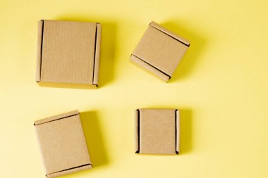 Sarı arka planda muhtelif boyutlarda karton kutular