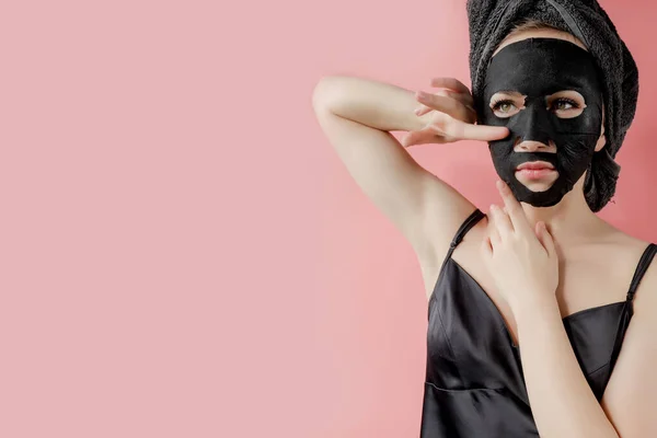 Jonge Vrouw Toe Passen Zwarte Cosmetische Stof Gezichtsmasker Roze Achtergrond — Stockfoto