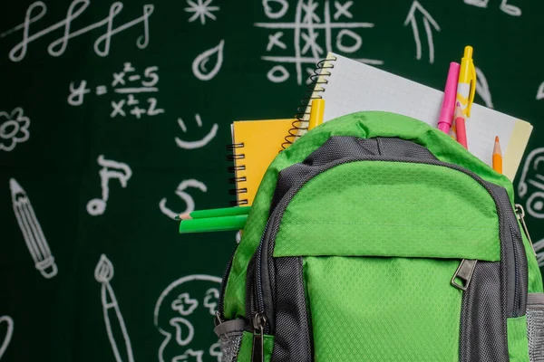 Bildungskonzept Grüner Rucksack Hefte Und Schulmaterial Auf Dem Hintergrund Der — Stockfoto