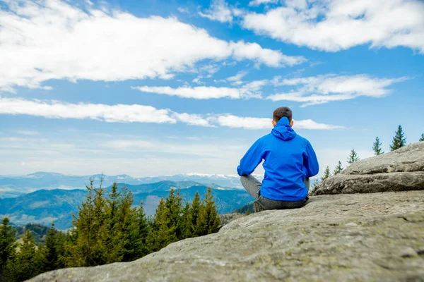 Harika bir dağ yerinde yoga yapan genç adam, yeni bir çağ, enerji, meditasyon ve sağlık, lotus pozisyonunda gülümseyen genç adam.