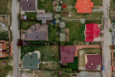 Asfaltlı, yeşil çimenli çimenli, beton zeminli bir evin havadan görünüşü.