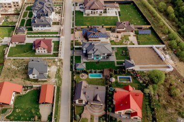 Beton zeminli yeşil çimenli asfalt bahçeli özel bir evin havadan görünüşü.