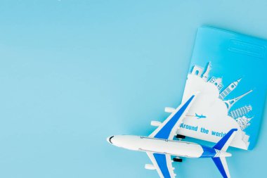 Pasaport ve uçak açık mavi arka planda. Yaz ya da tatil konsepti. Boşluğu kopyala