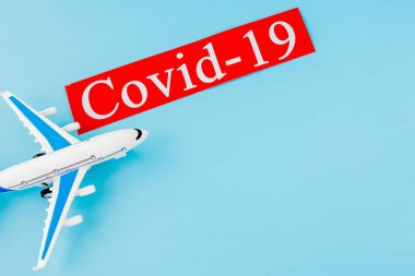 Uçak modeli oyuncağı ve COVID-19 metin konsepti. Coronavirus 'un etkisiyle uçuş iptali.